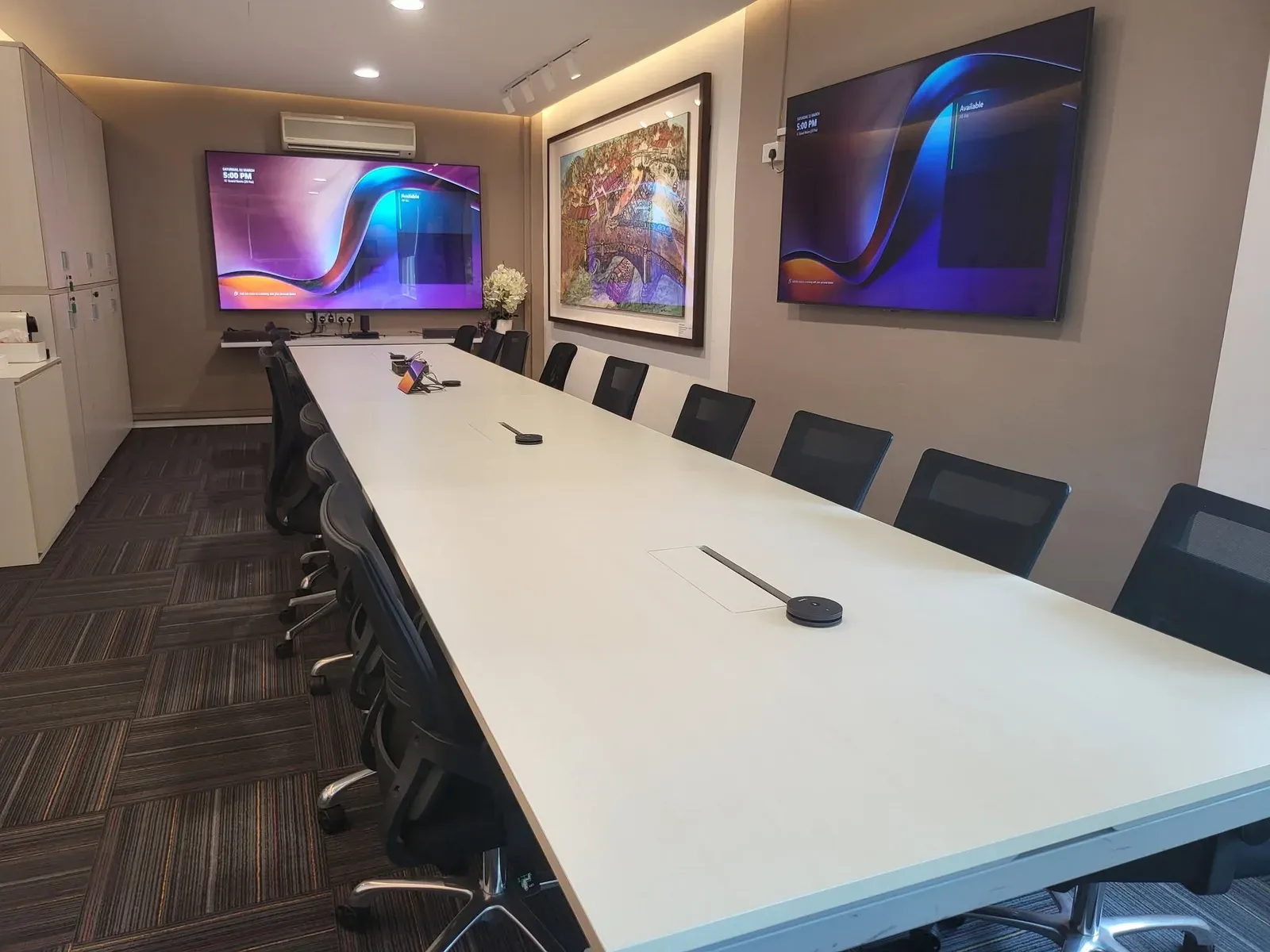 Long meeting table with two wall displays and table microphones