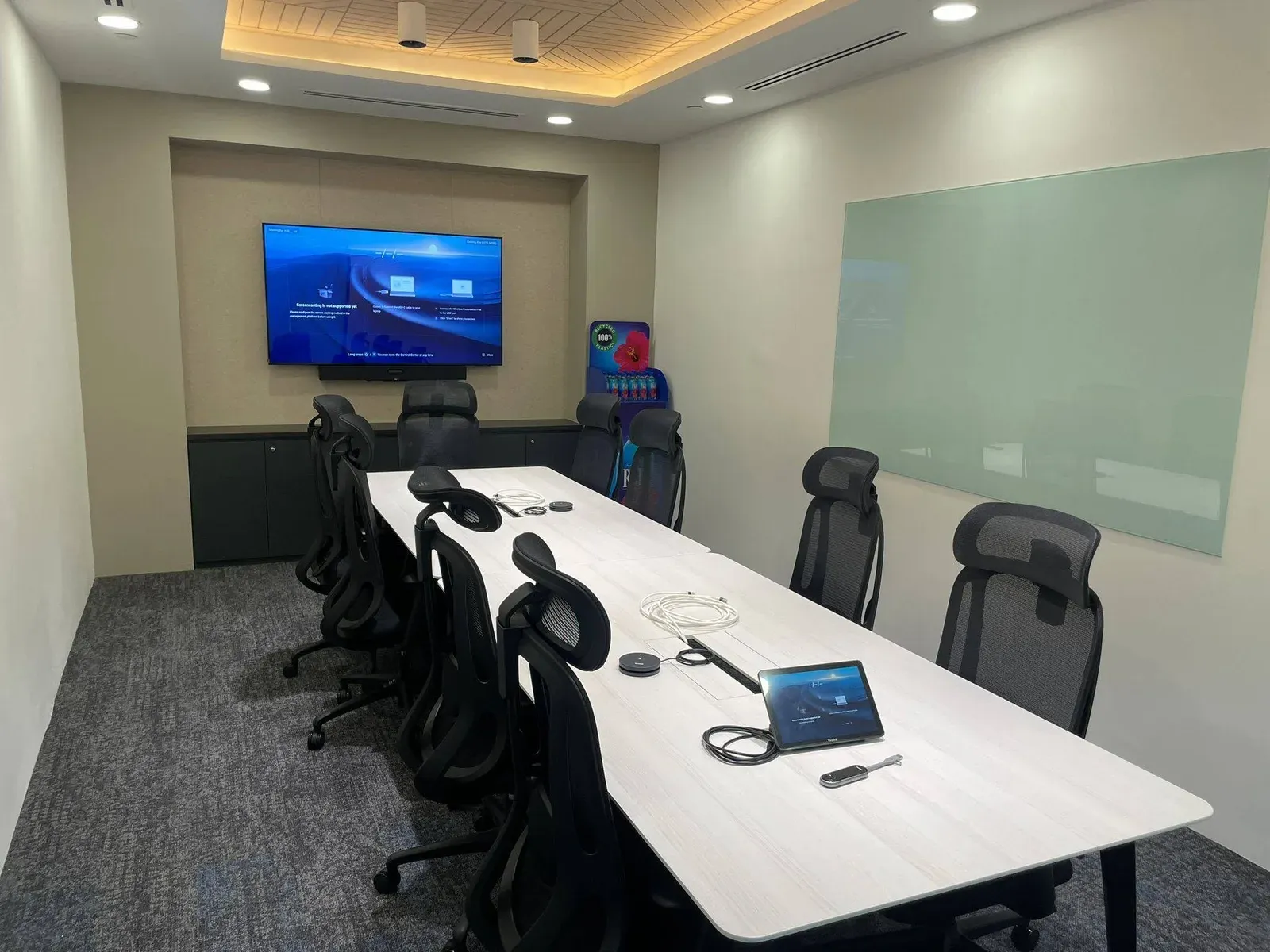 Mid-size meeting room with a wall display, video bar and table touch console, installed by VisionCast